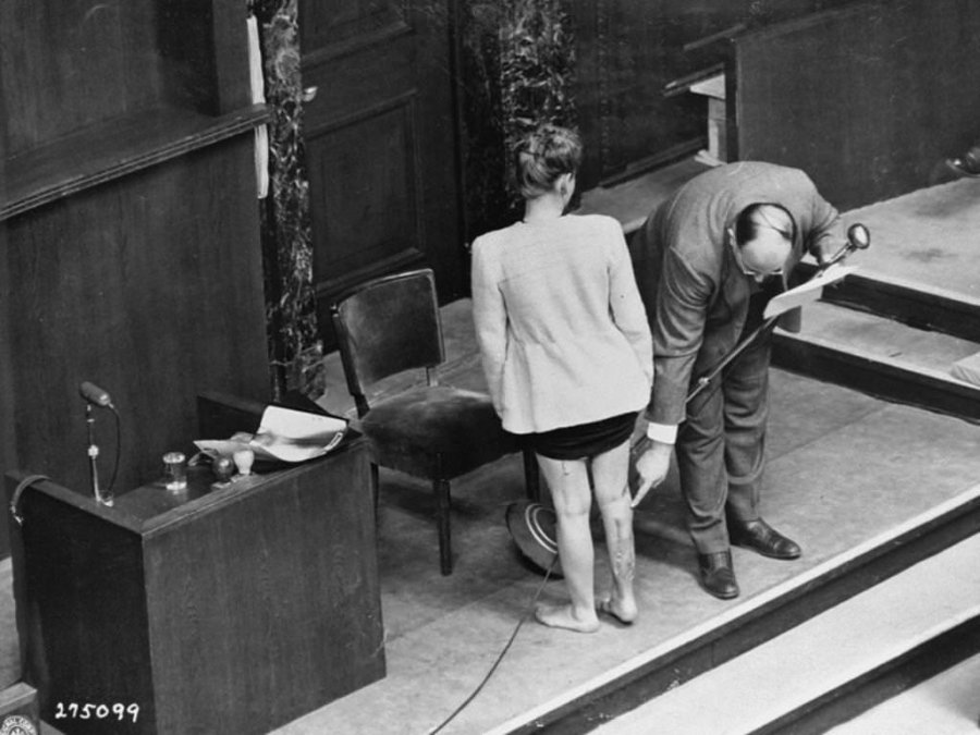 Durante el testimonio en el juicio de los doctores, un experto médico estadounidense, señala cicatrices en la pierna de Jadwiga Dzido, miembro de la clandestinidad polaca, víctima de experimentos médicos en el campo de concentración de Ravensbrück.
