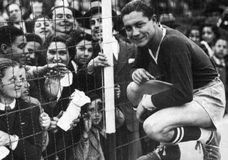 Arsenio Erico, máximo goleador histórico de Independiente y del fútbol argentino con 295 goles, posando con un grupo de admiradoras durante un partido de Independiente (1939).