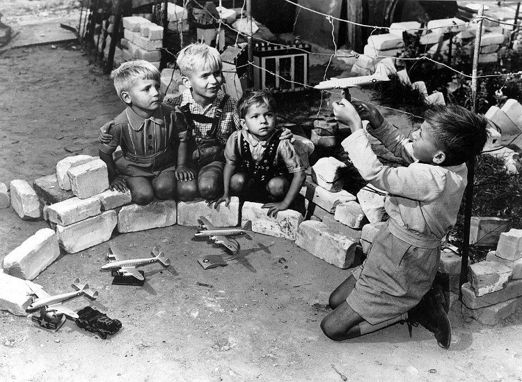 Niños alemanes con aviones de juguete.
