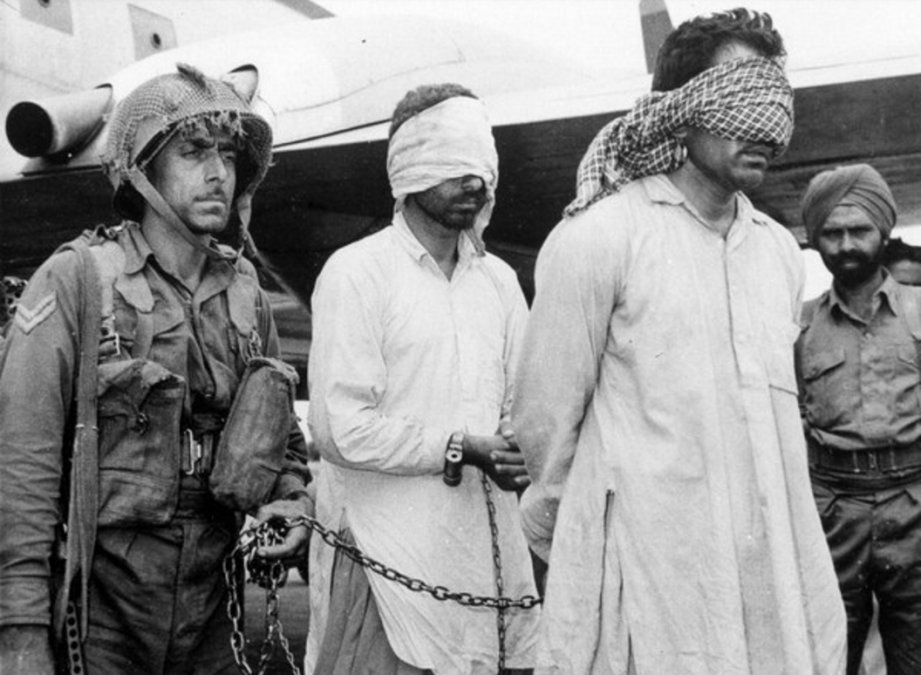         Dos oficiales pakistaníes escoltados por un soldado indio después de ser capturados (septiembre de 1965).