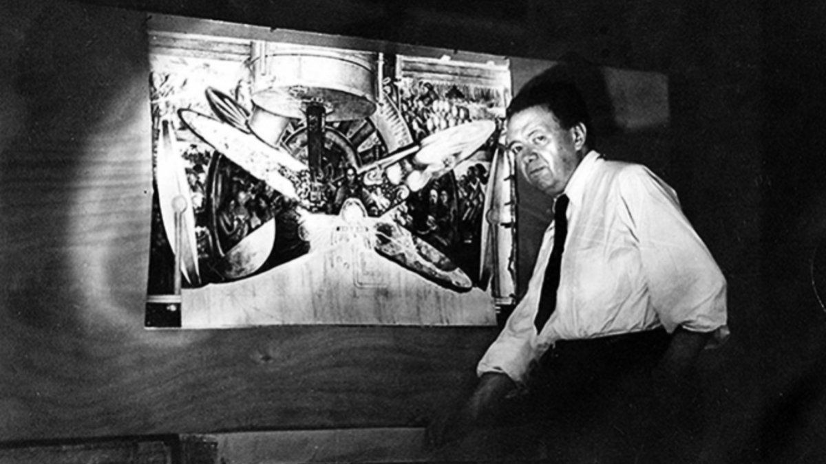 Diego Rivera posando junto al boceto de 