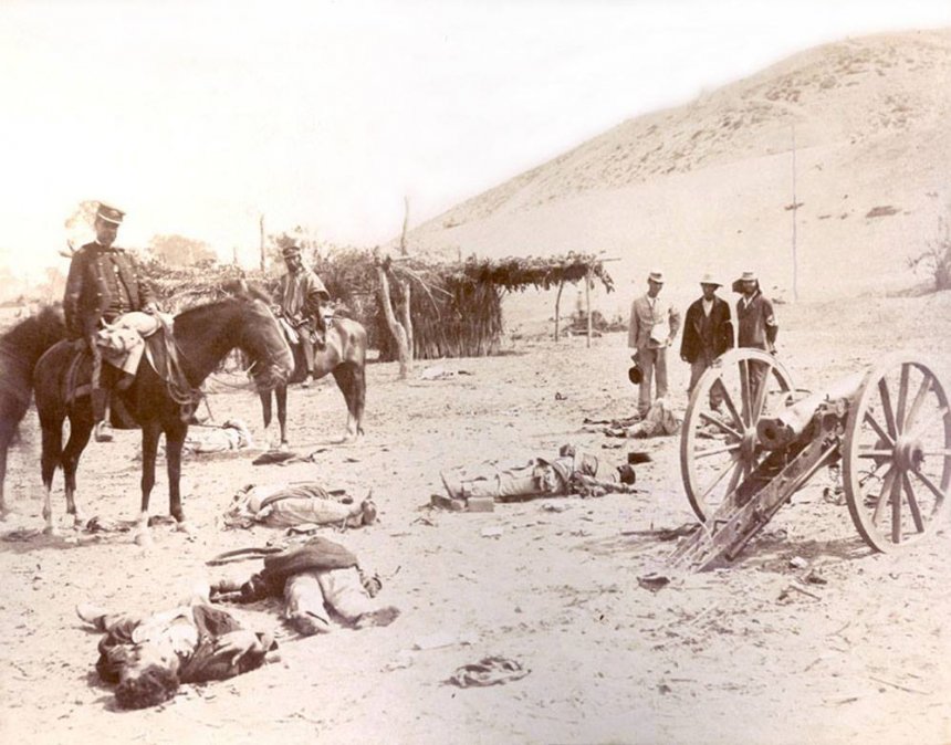 Martiniano Urriola (con uniforme), quien en 1883 comandó la ocupación de Ayacucho, y Marcos Maturana (con poncho), jefe del Estado Mayor del Ejército Expedicionario en la campaña de Lima, observan los cadáveres de los sirvientes de un cañón peruano tras la batalla de Chorrillos.