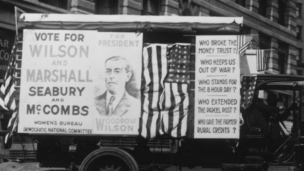 Un carro electoral promociona la reelección de Wilson con consignas como: 