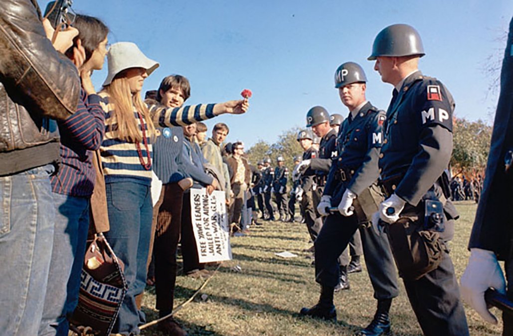 Manifestante ofreciendo una flor a un policía militar durante una protesta anti-Vietnam en Arlington, Virginia, en 1967. 