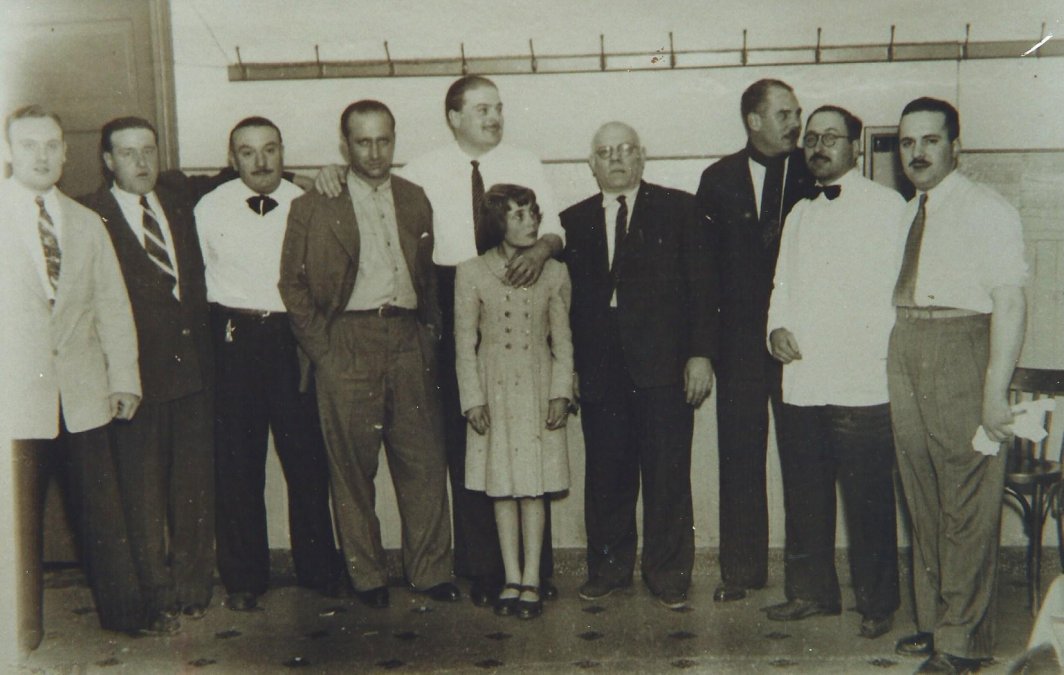 Fangio con los dueños y empleados  del Hotel La Catalana, además de familiares de los mismos. Los  propietarios eran Bartolomé Roig y Andrés Mas. El establecimiento  continúa funcionando de la mano de familiares de aquellos pioneros.