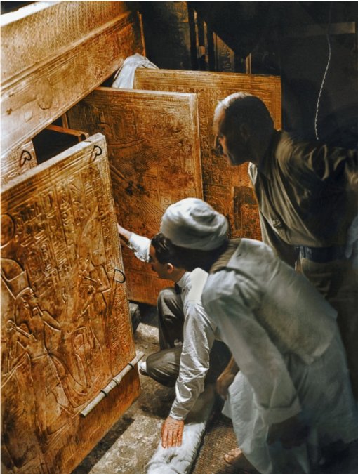 Howard Carter, agachado, abriendo por primera vez las cajas forradas de oro de la cámara funeraria. Foto Harry Burton.