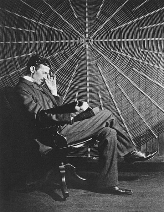 Nikola frente a una bobina de Tesla en su laboratorio de Nueva York, leyendo "Theoria Philosophiae Naturalis"