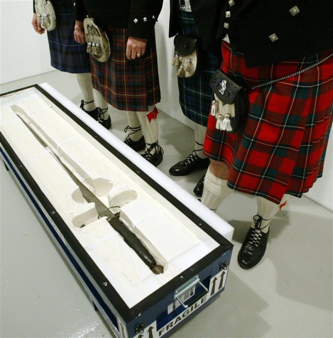 Varios miembros de un contingente escocés cuidan este tesoro nacional de  Escocia: una espada usada por el líder rebelde William Wallace, en  2005, en Nueva York, con motivo de una exposición temporal. Era la  primera vez en 700 años que este objeto abandonaba Escocia.