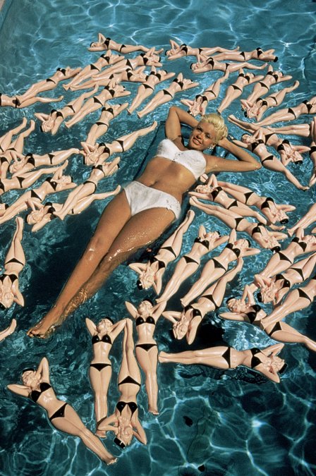  Jayne  Mansfield flota en una piscina de California en 1957. Eso que la rodean  no son muñecas de sí misma, no, es todavía mejor: son botellas con su  forma.  Getty Images