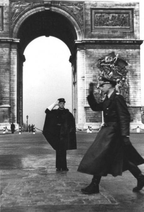 Gendarme francés y oficial alemán saludándose frente al Arco del Triunfo en París en 1941.