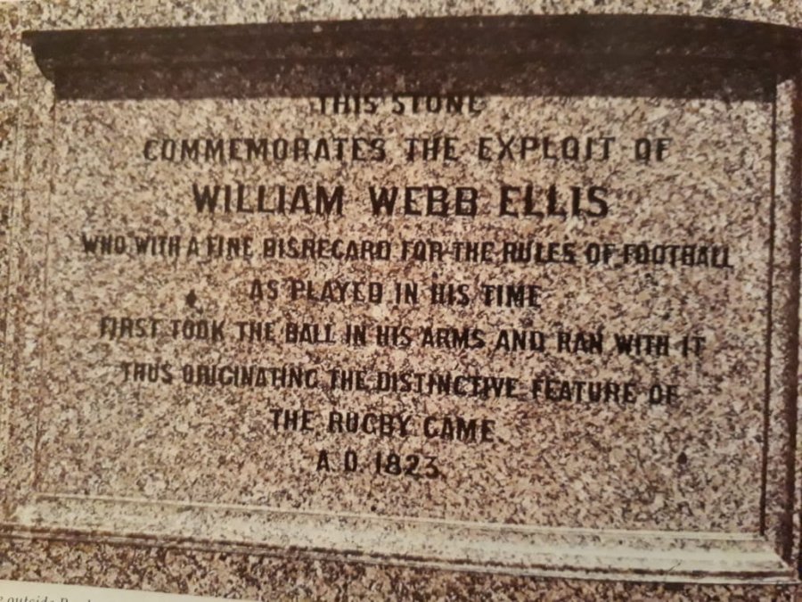 Placa conmemorativa de la acción de William Webb Ellis: «Esta piedra conmemora la proeza de William Webb Ellis  quien con fina desobediencia de las reglas del fútbol como se jugaba en  su tiempo tomó primero el balón en sus brazos y corrió con él  originando así la distintiva característica del juego de rugby A.D.  1823.».